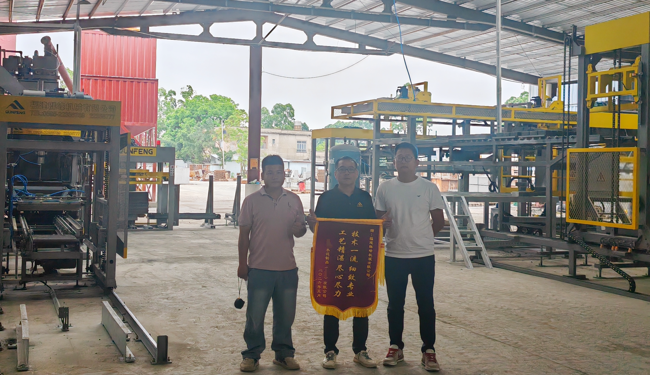 A Guangdong building materials client presenting a commemorative banner to the Qunfeng Machinery team at the project site एक गुआंग्डोंग निर्माण सामग्री ग्राहक परियोजना स्थल पर कुनफेंग मशीनरी टीम को एक स्मारक बैनर प्रस्तुत करता है