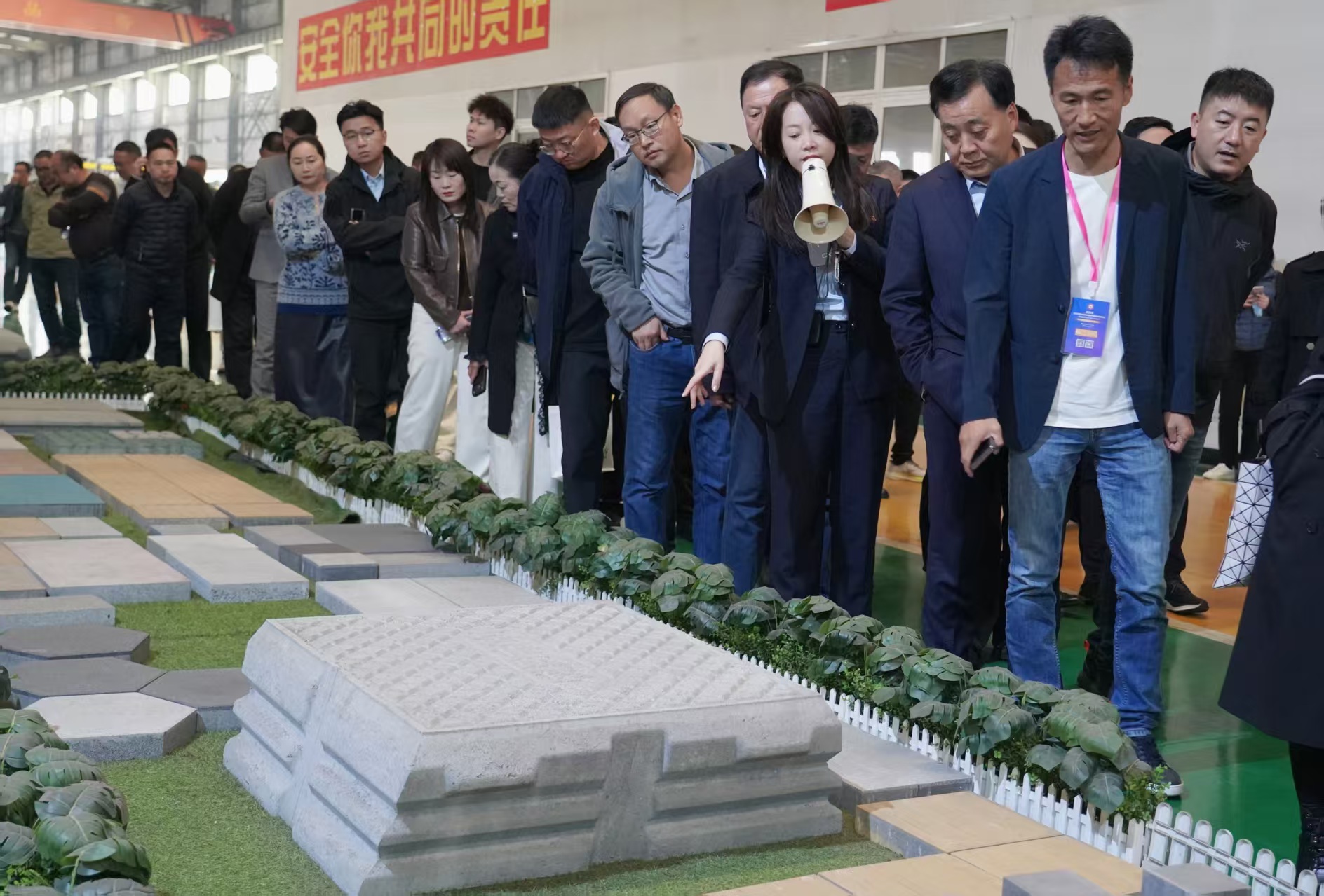 पीसी ब्लॉक उद्योग प्रतिनिधिमंडल स्वचालित ड्राई-कास्ट उत्पादन लाइन रोडबेड ब्लॉकों का अवलोकन कर रहा है